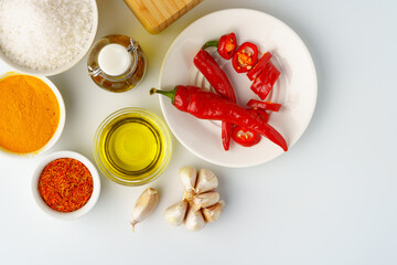 Bowls with spices and cooking ingredients on white background
