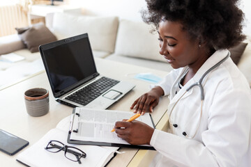 Serious concentrated African American doctor working in her office at clinic. Hardworking African...