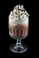 Coffee drink with cream and chocolate syrup in original glass tumbler. Isolated on a dark background