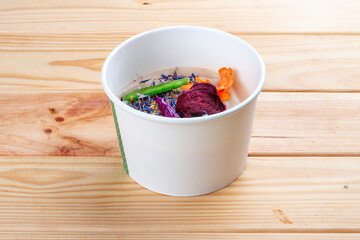 Celery root puree soup. Healthy diet. Takeaway food. Ecological packaging. On a wooden background.