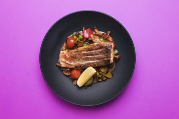 Appetizing fried piece of fish fillet on a colored background. Restaurant, banquet, buffet.