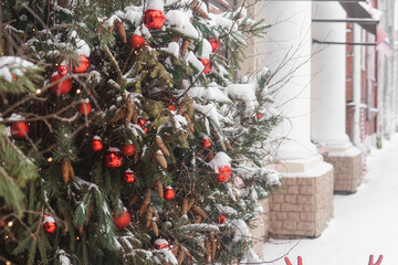 Christmas trees decorated with red balloons in front of the entrance to the cafe. Street Christmas decorations.