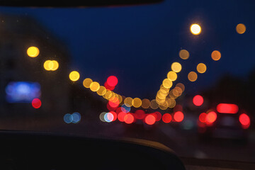 Car windshield view on New York night highway with car and street lamps. Defocused lights...