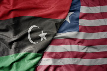 big waving national colorful flag of libya and national flag of liberia . - obrazy, fototapety, plakaty