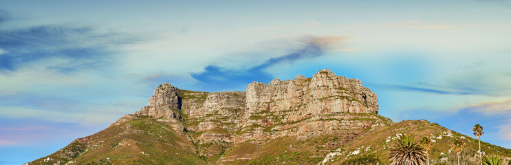 Low angle view of a mountain peak against a stunning colorful sky in South Africa. Scenic panorama landscape of a remote hiking location near Cape Town. Travel and explore nature through adventure