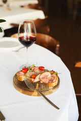 Appetizing bruschetta with thin pieces of meat on a light background. Food photography.