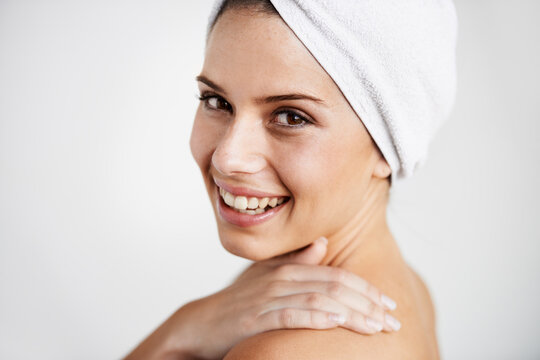 Smile, cosmetic and woman with towel in a studio for health, wellness and natural face routine. Happy, beauty and portrait of young female model with facial dermatology treatment by gray background.