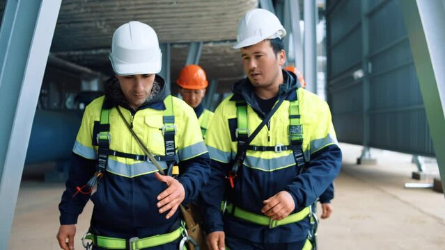 Team of industrial contractors builder metalworker walking at refinery workshop discuss job