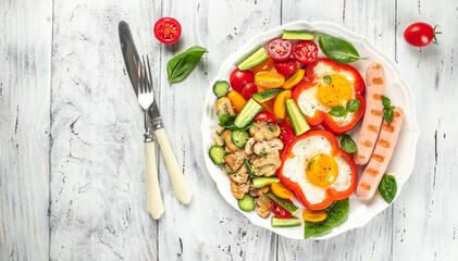 Breakfast set. fried eggs with sausages, mushrooms and vegetables on a light background top view. copy space