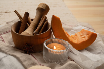 Cozy fall vibe.  Autumn evening with candle. Pumpkin with spices