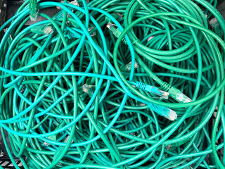 A messy pile of green Ethernet computer cables.