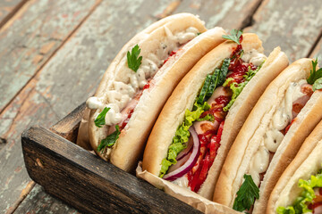 Hot dogs with fresh tasty buns and sausages on a wooden background. top view. copy space for text