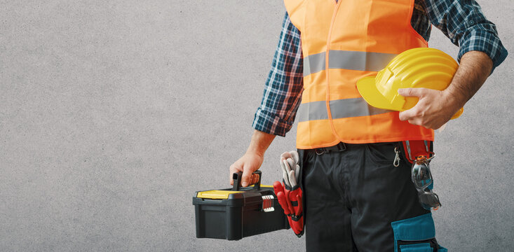 Repairman holding a toolbox and hard hat