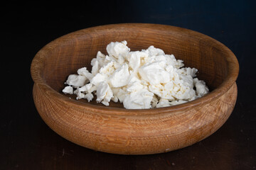 Homemade dietary cottage cheese in a wooden plate. Healthy home food