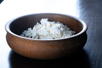 Homemade dietary cottage cheese in a wooden plate. Healthy home food