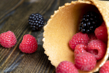 Ripe red raspberries in a crispy waffle cone