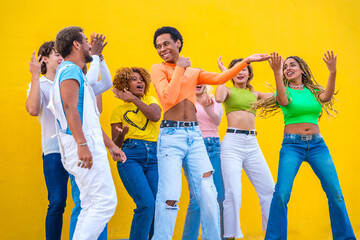Fototapeta premium Young people with colorful clothes dancing together outdoors