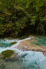 The waterfalls and crystal clear, blue, turquoise and green waters of the Nacedero del Urederra, with its beech forest with its autumn colors in the Sierra de Urbasa-Andía. Navarre. Spain