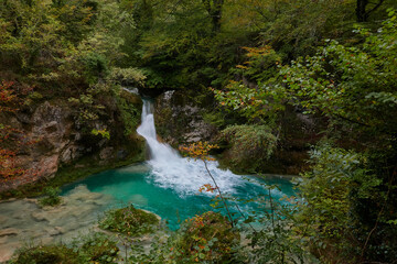 The waterfalls and crystal clear, blue, turquoise and green waters of the Nacedero del Urederra, with its beech forest with its autumn colors in the Sierra de Urbasa-Andía. Navarre. Spain