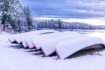 first snow fall of the year covers canoes on the shore of the ottawa river in  morning