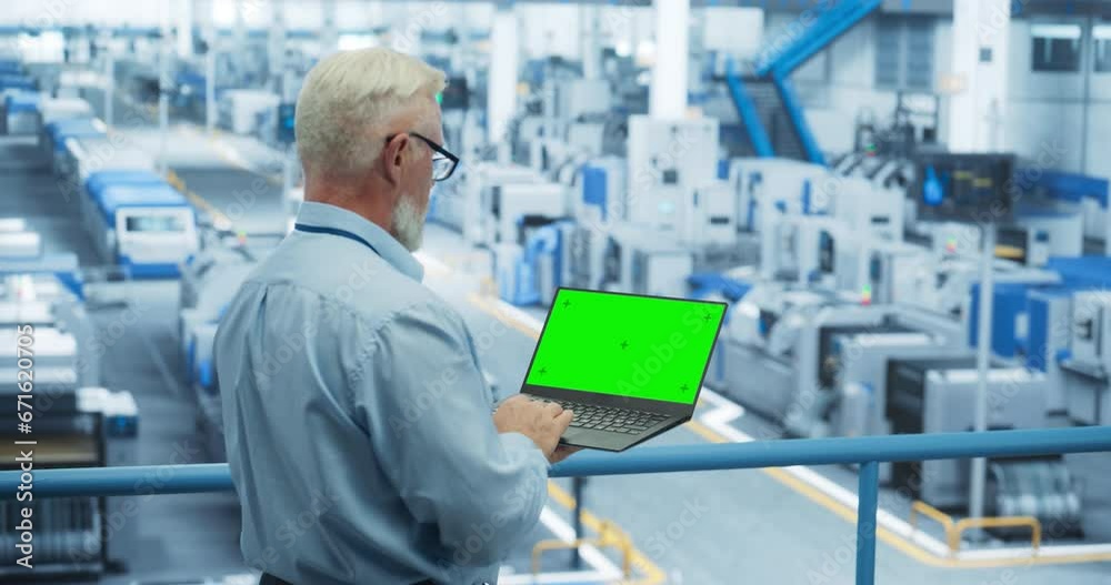 Fototapete Electronics Manufacturing Project Manager Working on Laptop Computer with Green Screen Template at a Factory. Middle Aged Specialist Developing, Maintaining, Upgrading Programs for Machine Production