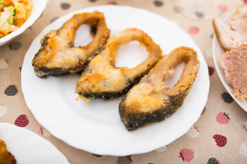Three pieces of fried carp on a white plate