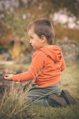 Little boy playing in garden as a craftsman in nice autumn day