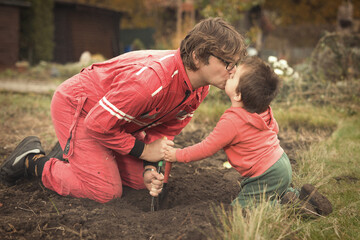 Little boy with his father playing as a craftsman and gardener in autumn