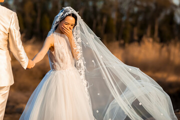 bride and groom walking in park