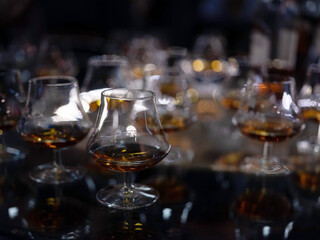 Glass of brandy or cognac on the bluring background