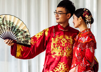 Man and woman in traditional clothes holding fans