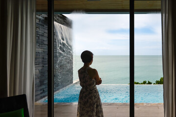 Happy senior digital nomad woman relaxing stand at luxury pool villa near beach, Phuket Thailand. - obrazy, fototapety, plakaty