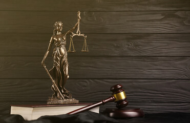 The Statue of Justice - lady justice or justitia the Roman goddess of Justice. Statue on brown book...
