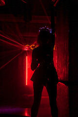 Perfect erotic show showgirl slim woman in night club party dancing in red neon light background. Silhouette of stripper lady in stage costume on dance stage. Party perform concept. Copy ad text space