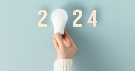 Energy saving lamp in woman's hand. Energy saving in new year concept.