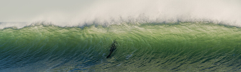 A surfer passes through a beautiful and huge green wave at the spot of La Sauzaie, Vendée, FRANCE.