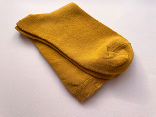 Two orange new socks folded together in half on a pink background, close-up, top view. Warm cotton socks. Style.