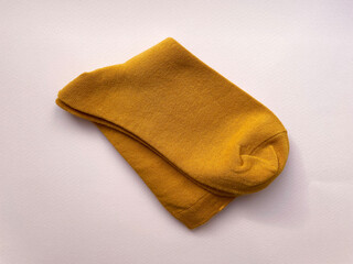 Two orange new socks folded together in half on a pink background, close-up, top view. Warm cotton socks. Style.