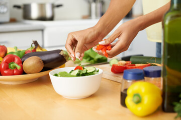 Hands, cooking and salad with a person in the kitchen of a home closeup for health, diet or...