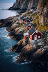 Traditional red Rorbu fisherman's huts on the rocky coastline of Lofoten Islands, Norway. - obrazy, fototapety, plakaty
