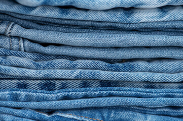 Stack of blue jeans, close-up. Texture and background.
