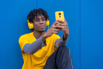 African young man taking a selfie while listening to music