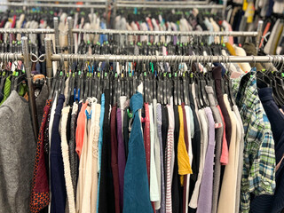 Many clothes hang on the metal rack for sale