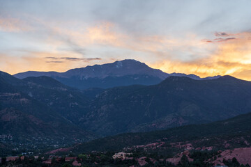 A colorful sunset over Pike's Peak and other blue mountains and red rocks on a fall/summer evening, as viewed from Garden of the Gods in Colorado Springs, CO