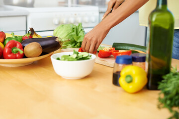 Obraz na płótnie Canvas Hands, food and salad with a person in the kitchen of a home closeup for health, diet or nutrition. Cooking, bowl and ingredients for a vegetarian meal with an adult in an apartment for dinner