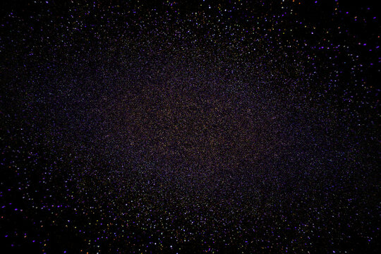 Black dark indigo blue gold orange glitter shiny abstract background for design. Twinkling glow stars effect. Fantastic, fantasy. Like outer space, night sky, universe. Grain, rough surface.