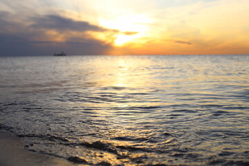 Autumn Sunset on the seashore. Reflection of the sun's rays in the sea waves.