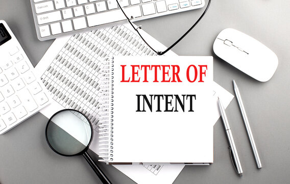 LETTER OF INTENT text on notebook with clipboard and calculator on a chart background