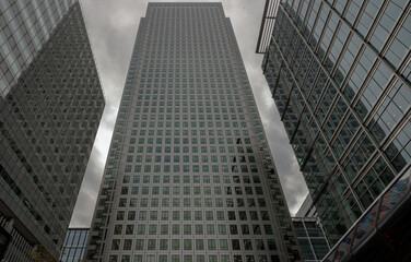 Fototapeta na wymiar Upward view of Skyscrapers in the business district area of One Canada Square in Canary Wharf. Tall structure architecture in the capital city. Architectural exterior view, Copy space, Selective focus