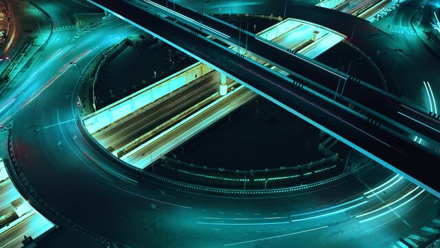 Financial technology, energy power, beautiful top view time-lapse of car traffic at roundabout lane and buildings. 4K drone aerial zoom out. Urban cityscape concept or abstract of advanced innovation.